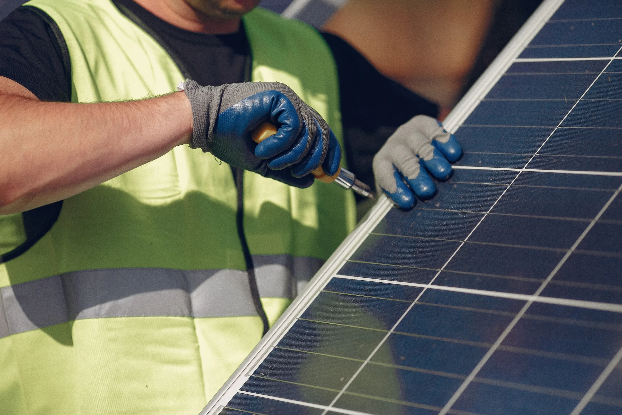 Solar technician working beside a solar panel system