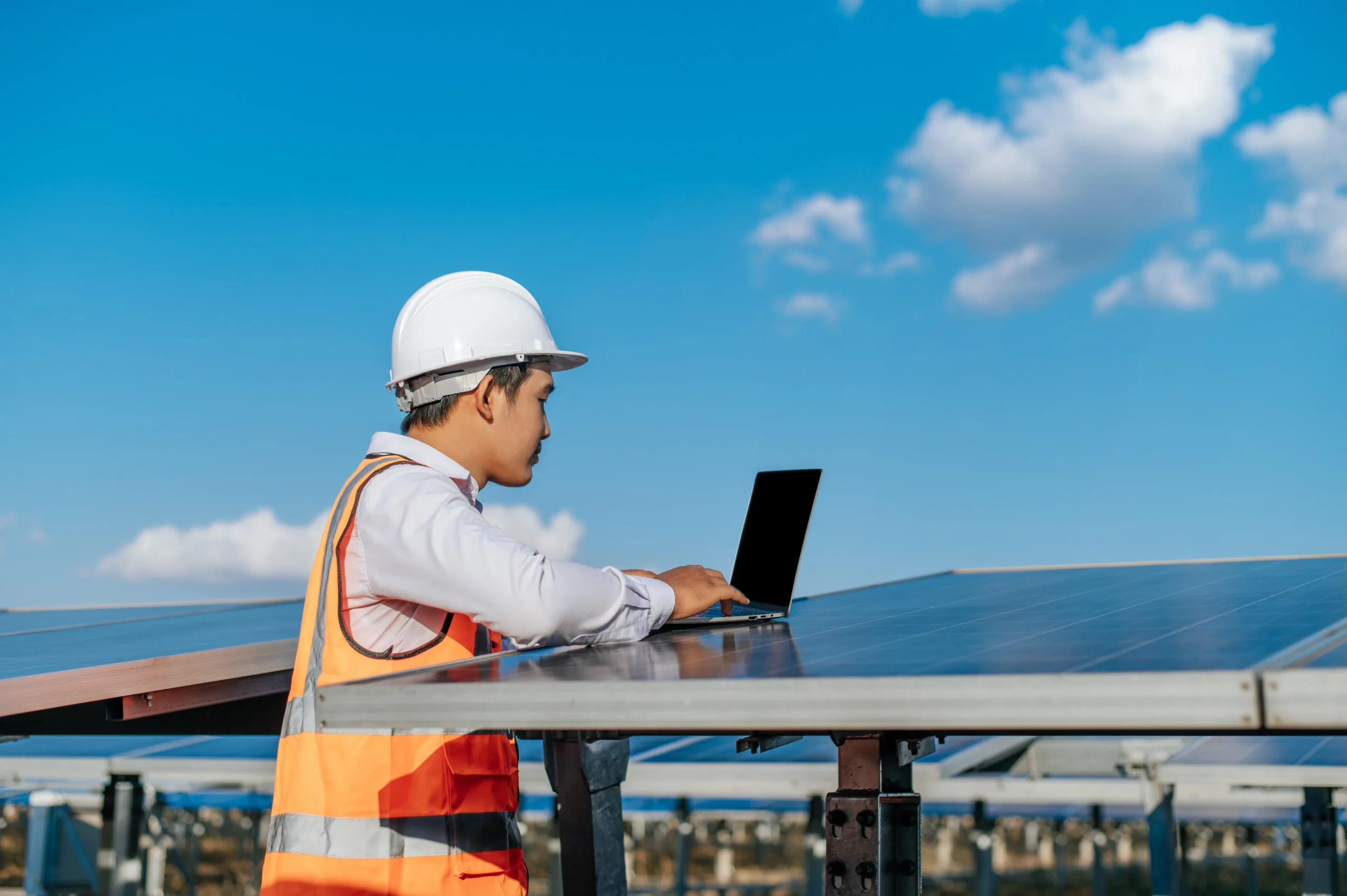 Solar technician using a laptop to inspect system performance